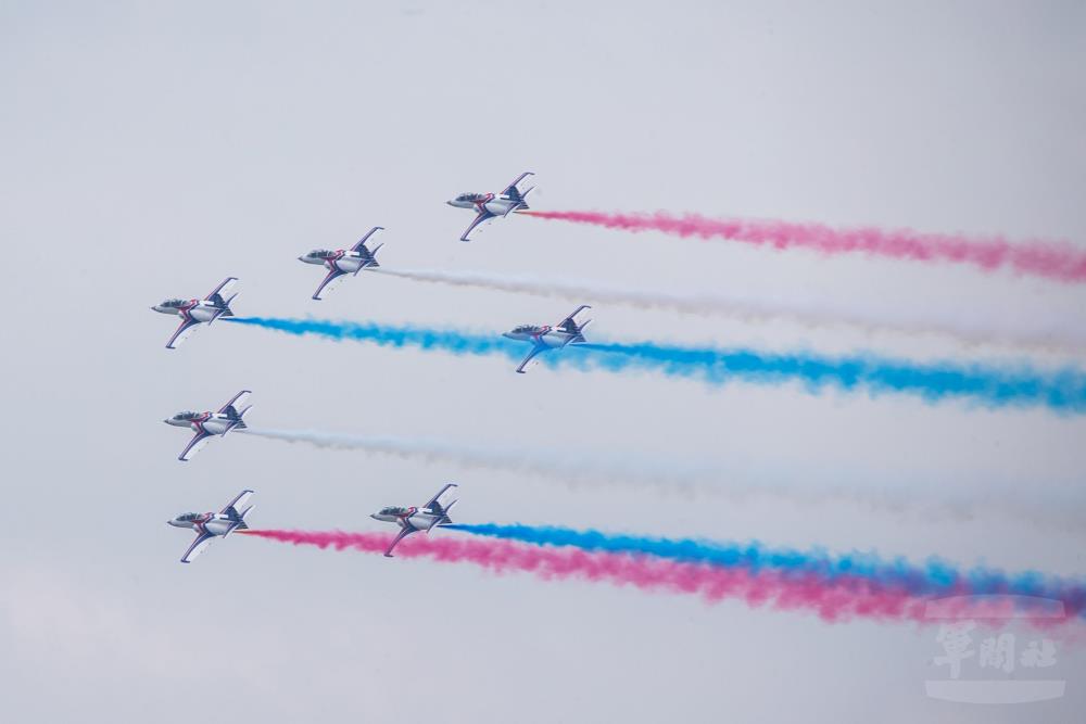 空軍AT-3教練機施放象徵國旗顏色的「紅、藍、白」三色彩煙由西向東通過總統府上空。（軍聞社記者莊家宏攝）