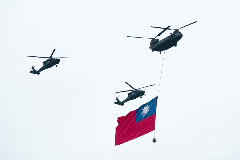 CH-47SD直升機於國歌頌唱時，吊掛巨型國旗，通過觀禮臺上方。（軍聞社記者林庭暉攝）