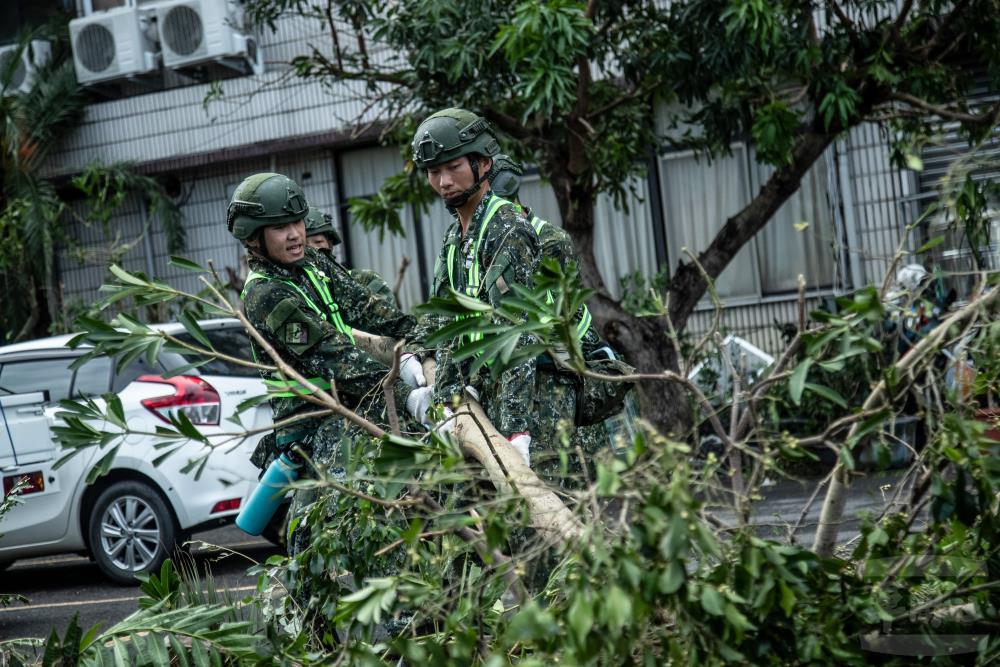 官兵清理倒塌路樹，加速交通動線暢通。（軍聞社記者王茗生攝）