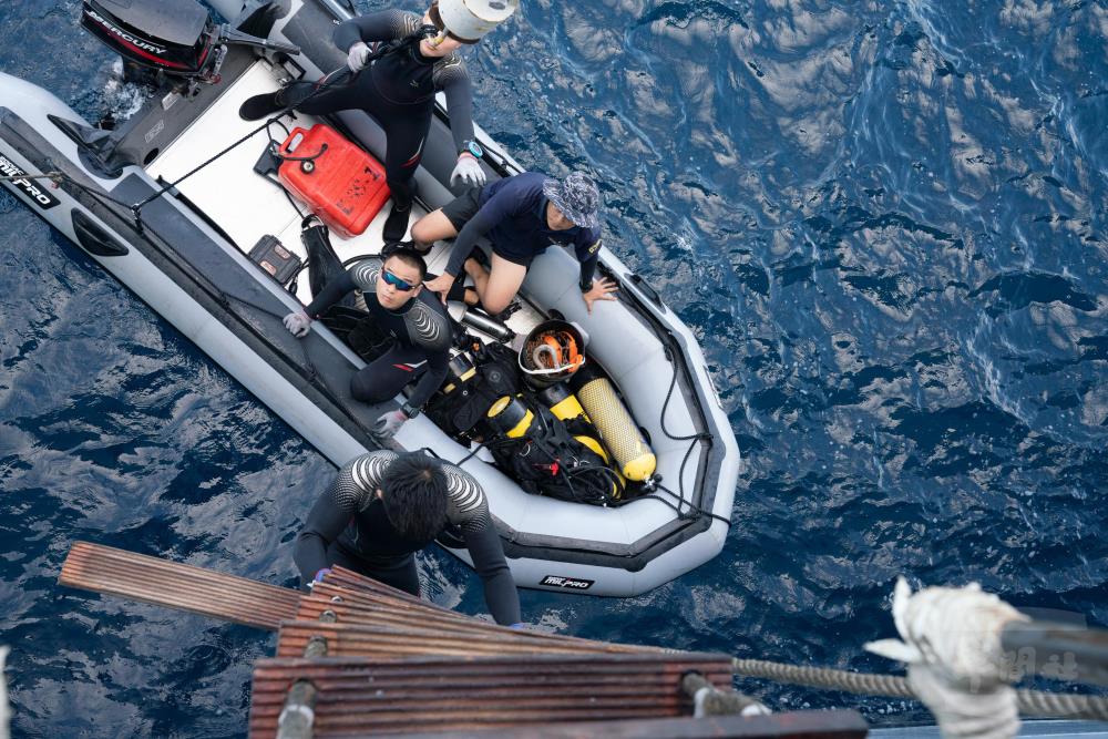 水下作業大隊人員用最快速度攜帶所需裝備，搭乘小艇前往檢視。（軍聞社記者吳柏融攝）