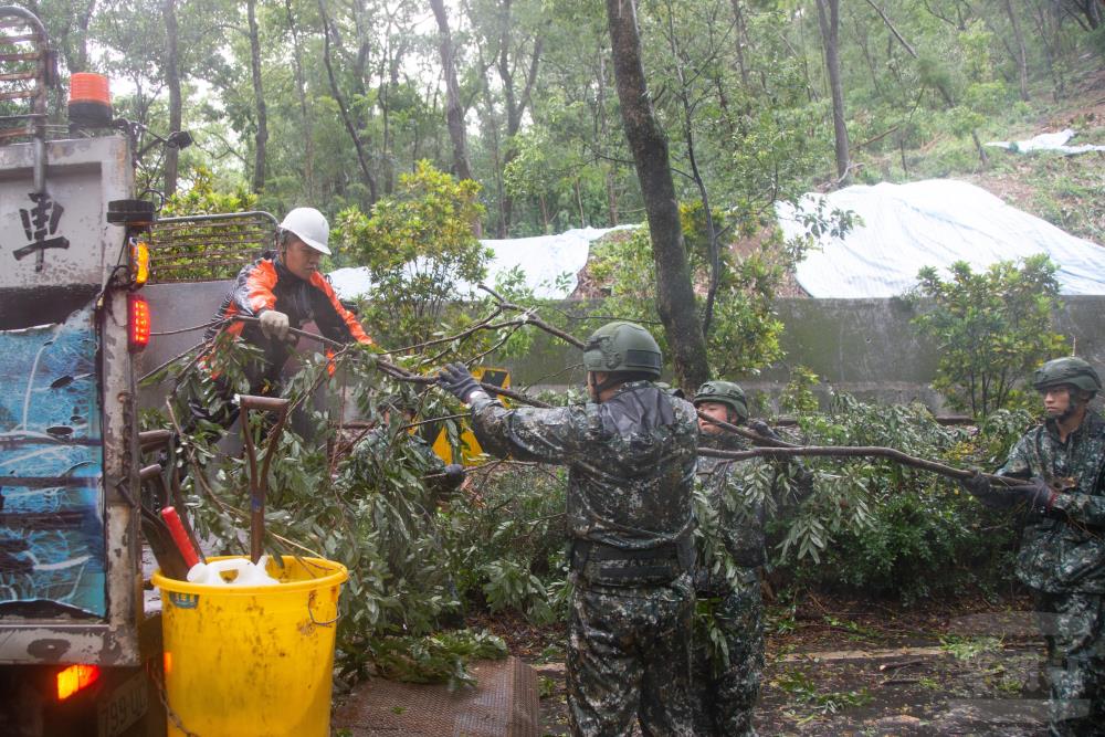 兵整中心官兵於南投集集綠色隧道清除大型斷枝恢復道路通暢。（軍聞社記者卓以立攝）