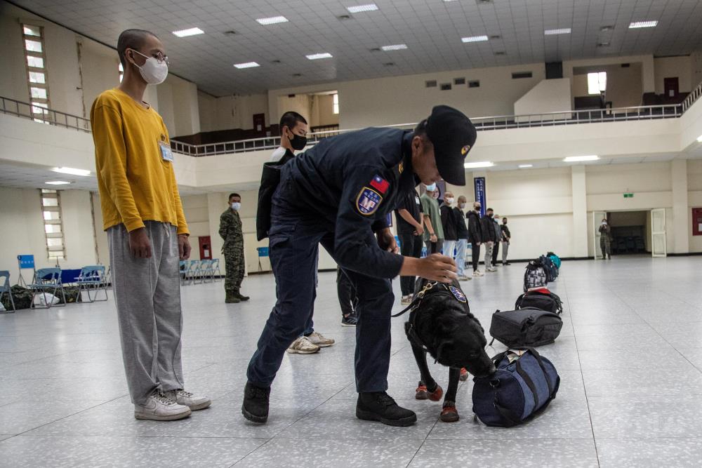 緝毒犬逐一針對報到役男的隨身行李，執行預防性毒品搜查。（軍聞社記者王茗生攝）