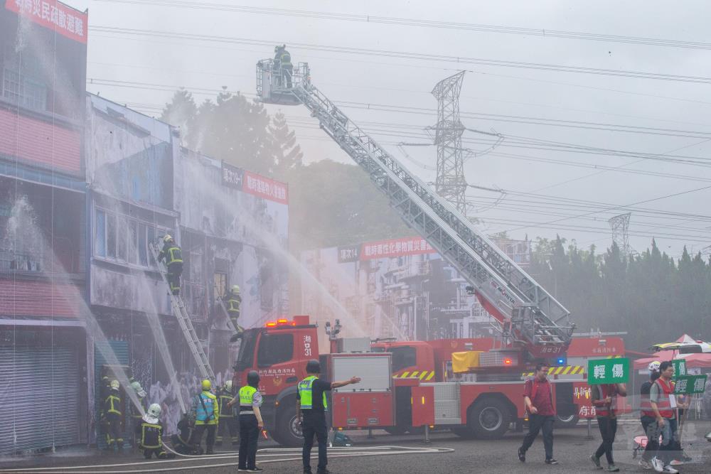 消防人員運用各式裝備器材搜救因火災受困大樓民眾。（軍聞社記者莊家宏攝）